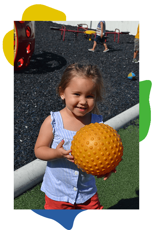 Child with a ball playing outside.